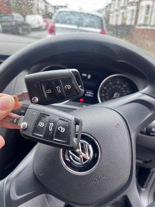 Two Volkswagen car keys held in front of a steering wheel, from YOUFIX’s key work